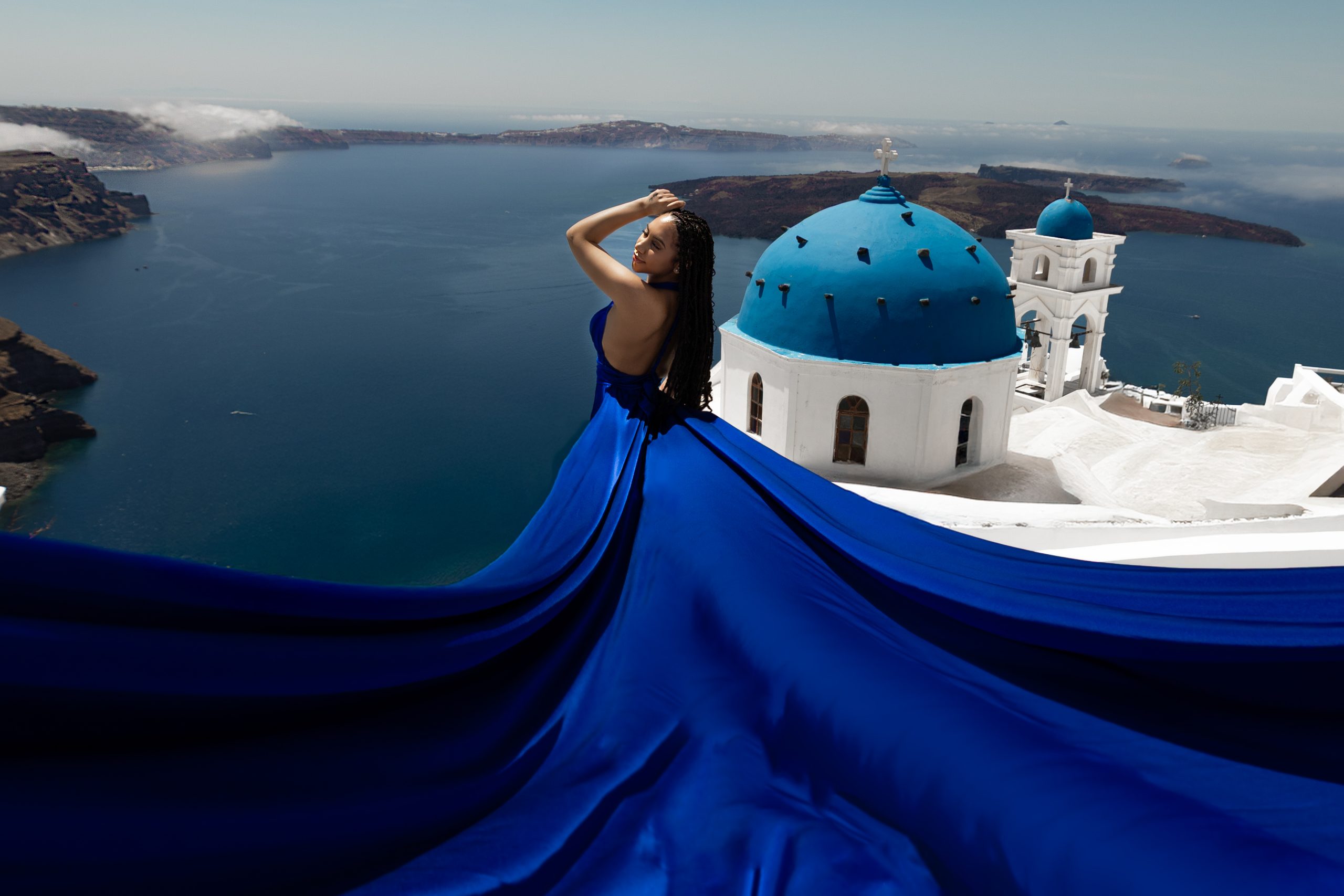Santorini photoshoot overlooking white villages, blue domes and the caldera
